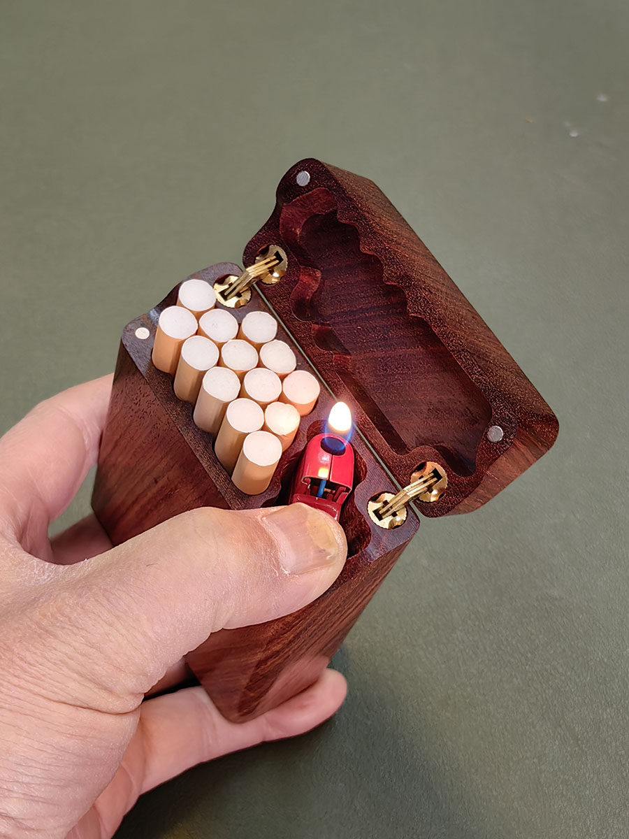 무지탕 설탄[MUZITANG XUETAN]은 속이 빈 조잡한 담배를 손으로 말아서 만든 견고한 목재 휴대용 담배 케이스로 라이터를 담을 수 있는 플립탑 뚜껑이 있습니다