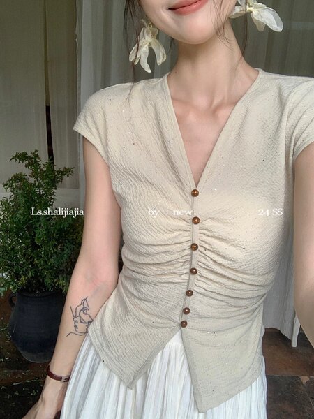 Beige ruched button-front short-sleeve top worn by a model