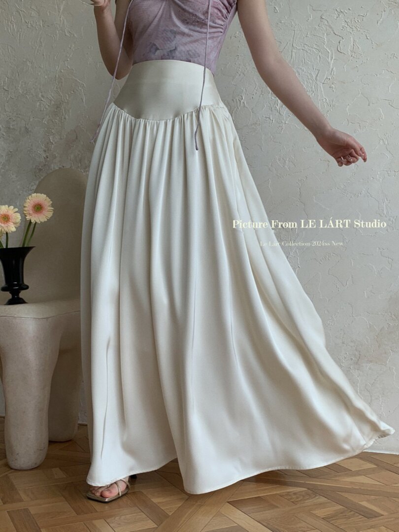 Woman wearing a cream flowing maxi skirt with a high waistband