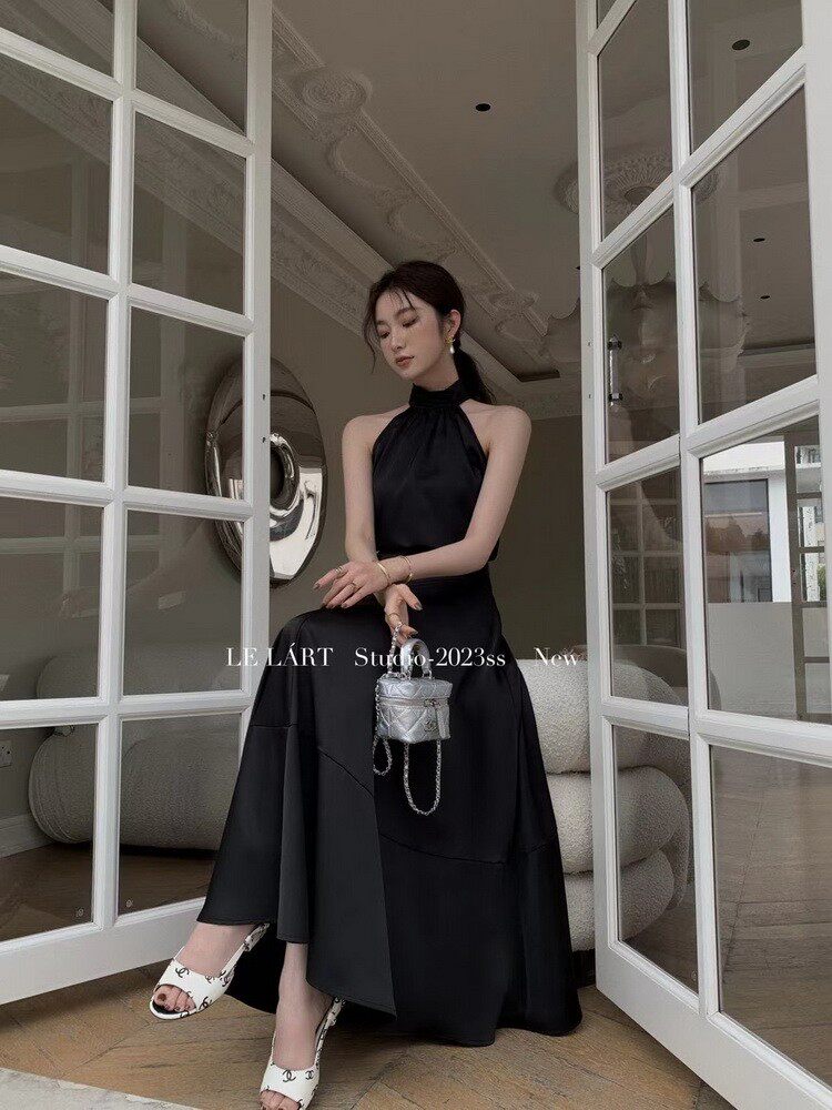 Black halter-neck maxi dress worn by a model indoors