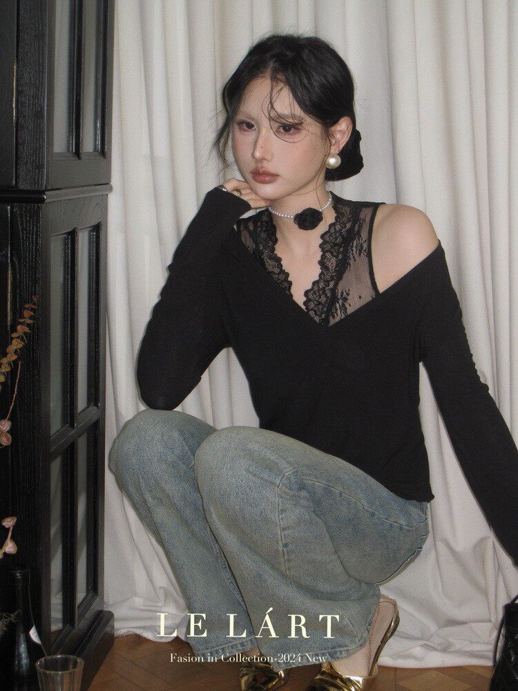 Model wearing a black lace-trim off-shoulder top with light blue jeans