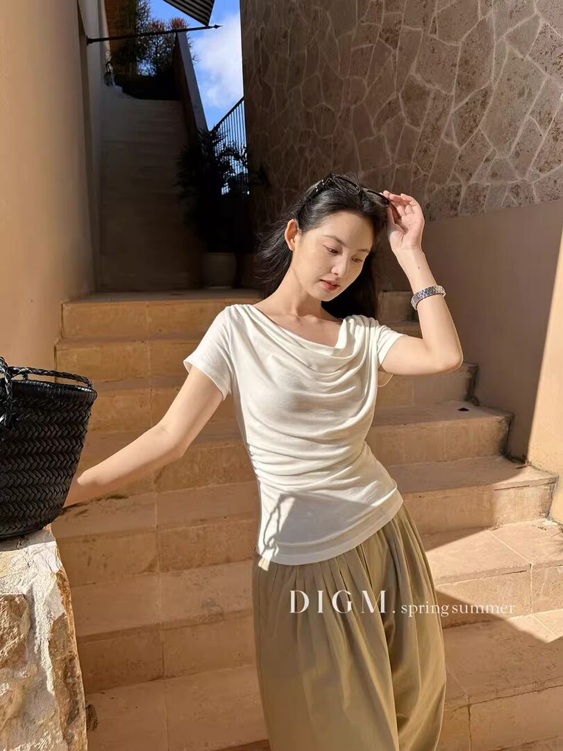 Woman wearing a white draped top with beige wide-leg pants