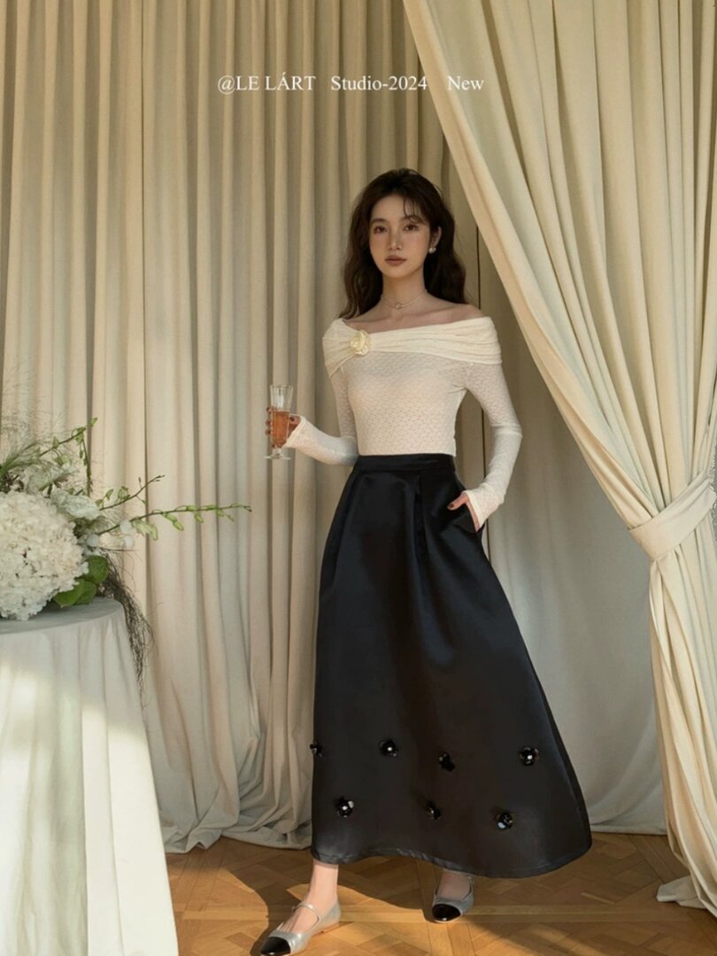 Woman wearing an off-shoulder white top and long black skirt