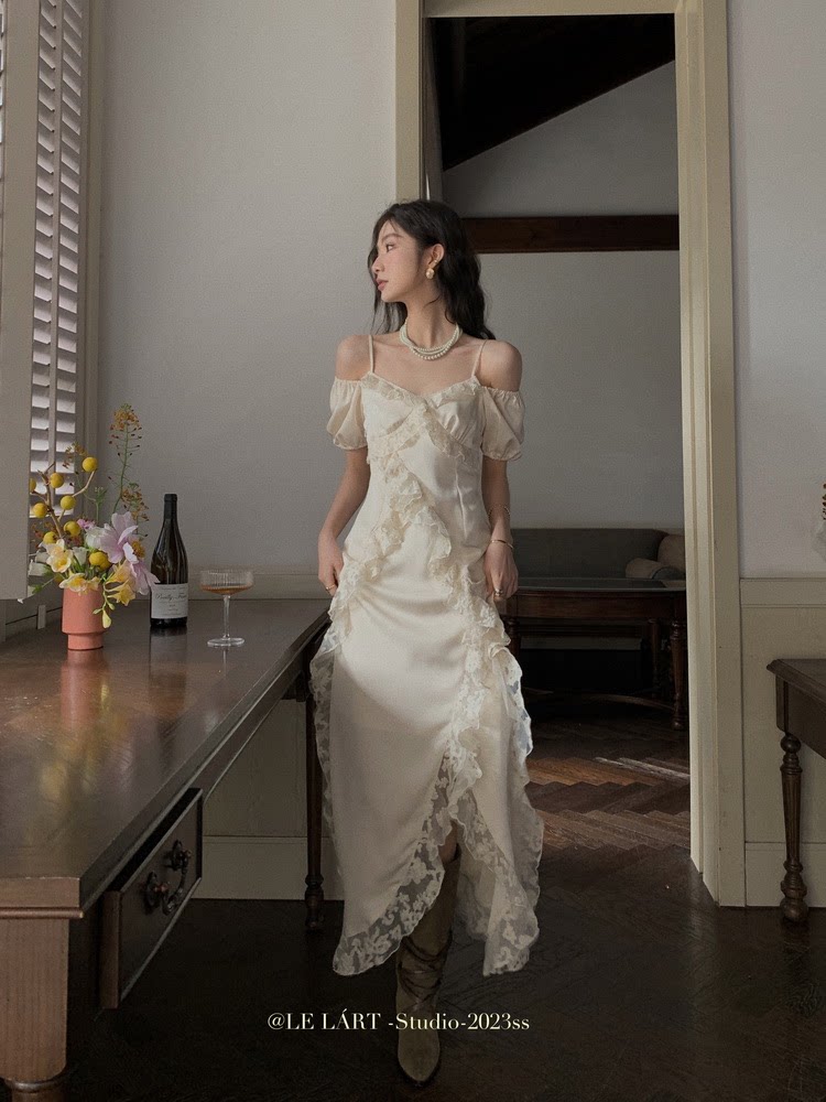 Woman wearing a cream off-shoulder lace dress indoors