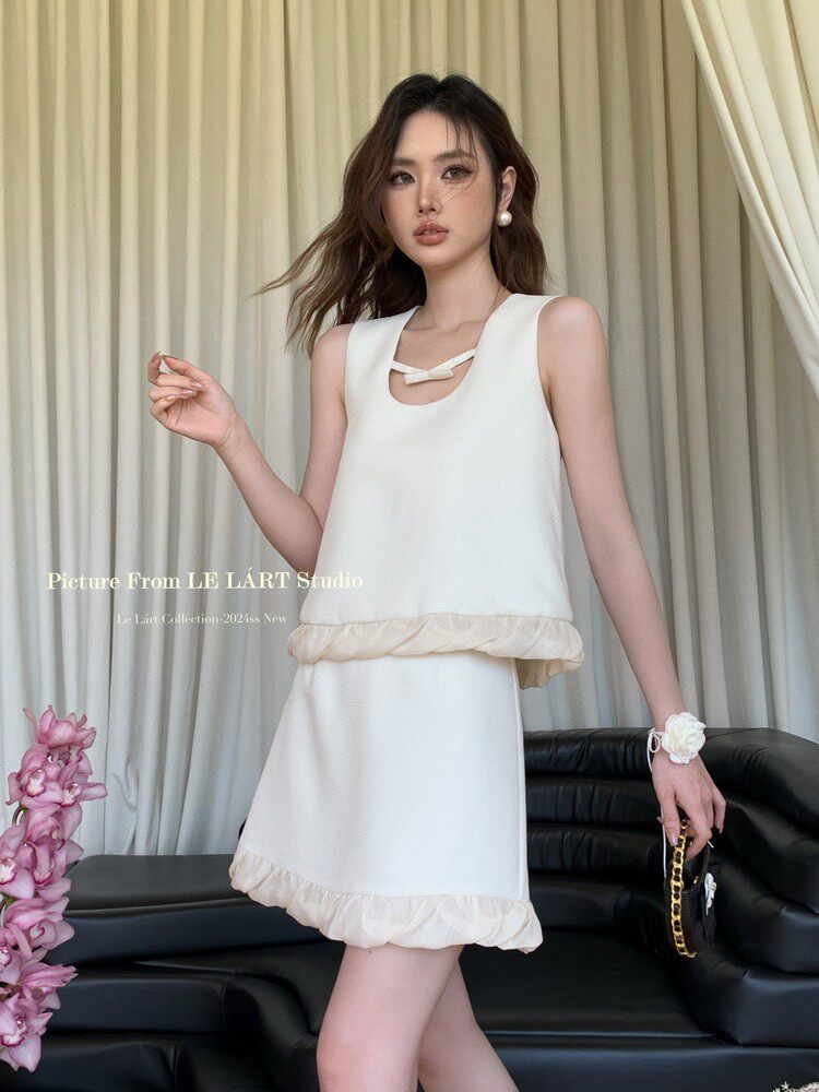 White sleeveless mini dress worn by a model