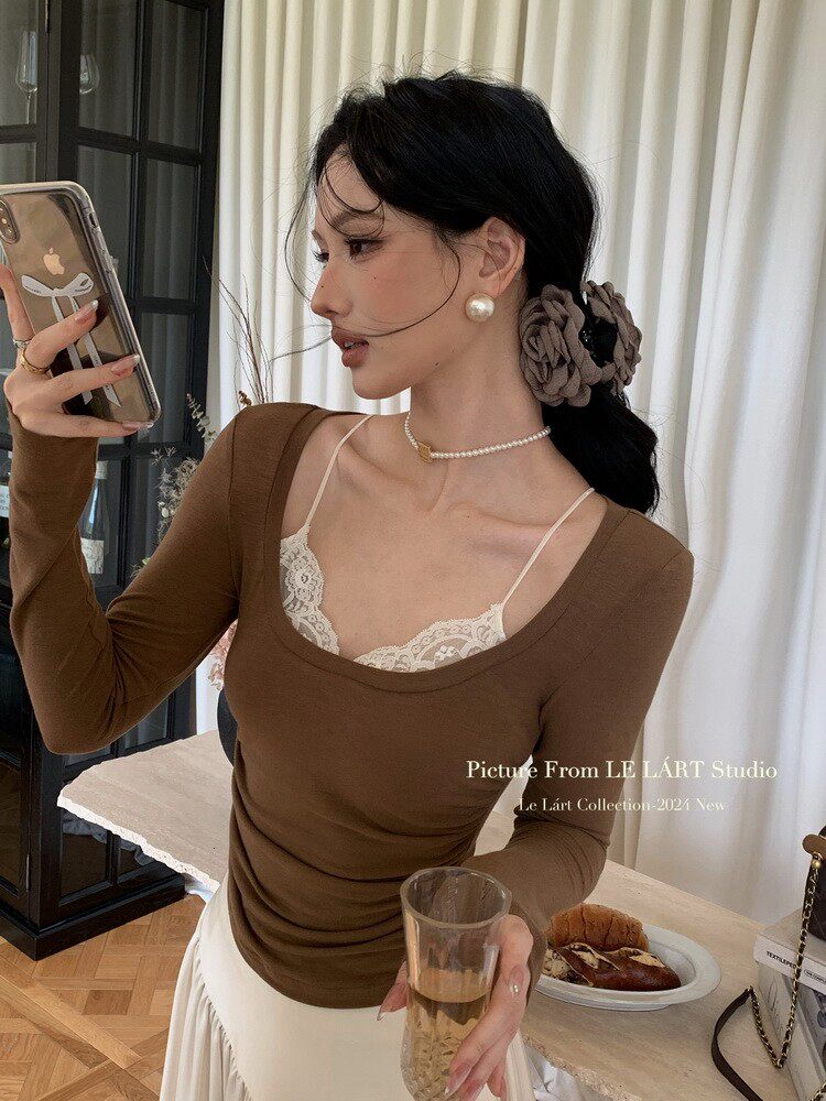 Brown fitted long-sleeve top worn over a lace camisole