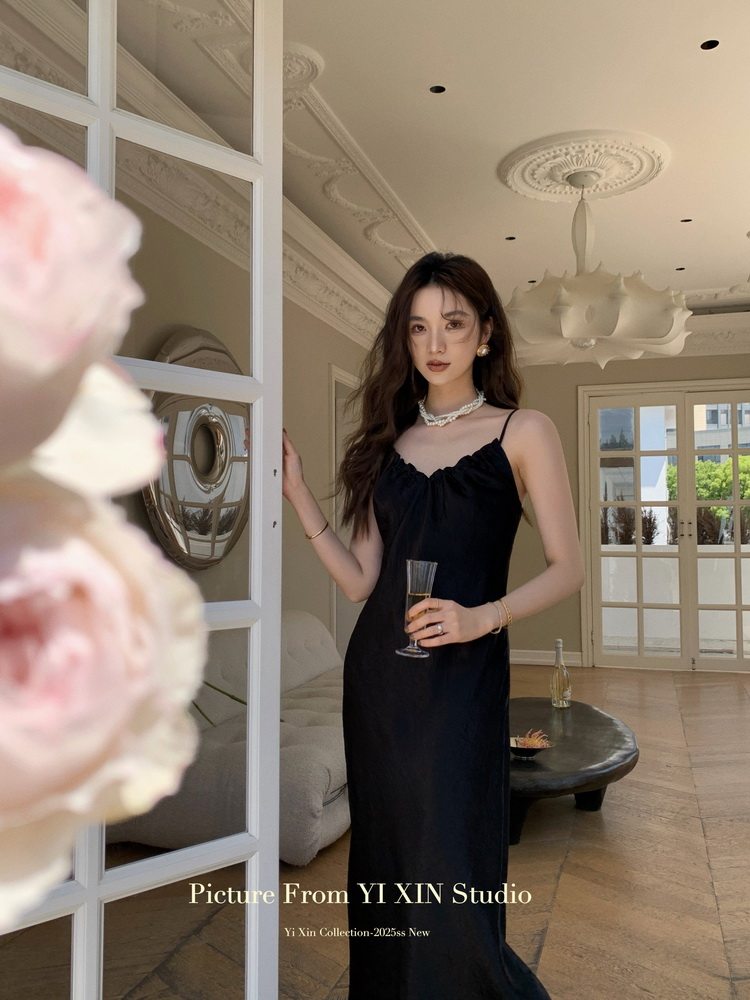 Black sleeveless long dress worn by a model indoors