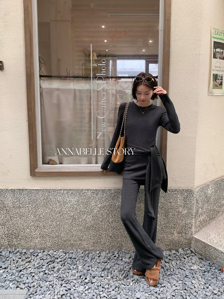 Woman wearing a dark knit matching set with long-sleeve top and flared pants