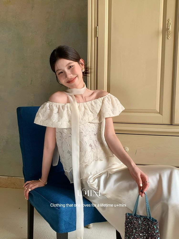 Woman wearing a white off-shoulder lace dress with a satin skirt