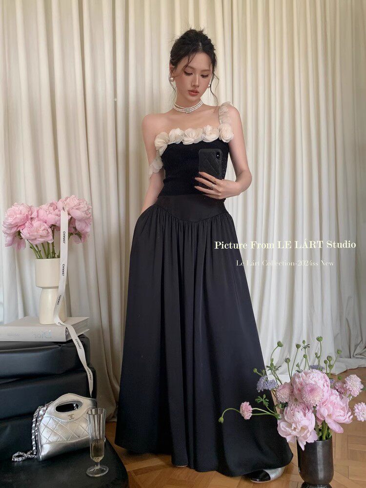 Black strapless maxi dress worn by a model with floral trim detail