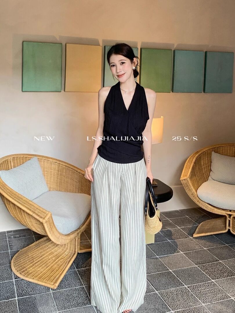 Woman wearing a black halter top with wide striped pants