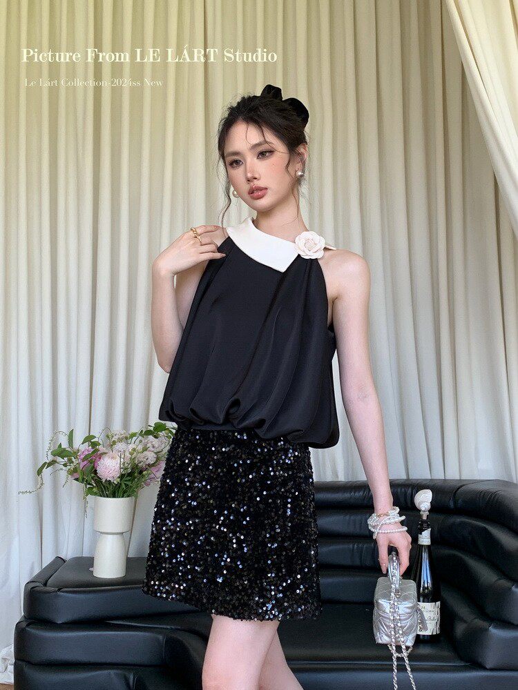 Model wearing a black halter top with white collar and a black sequined skirt