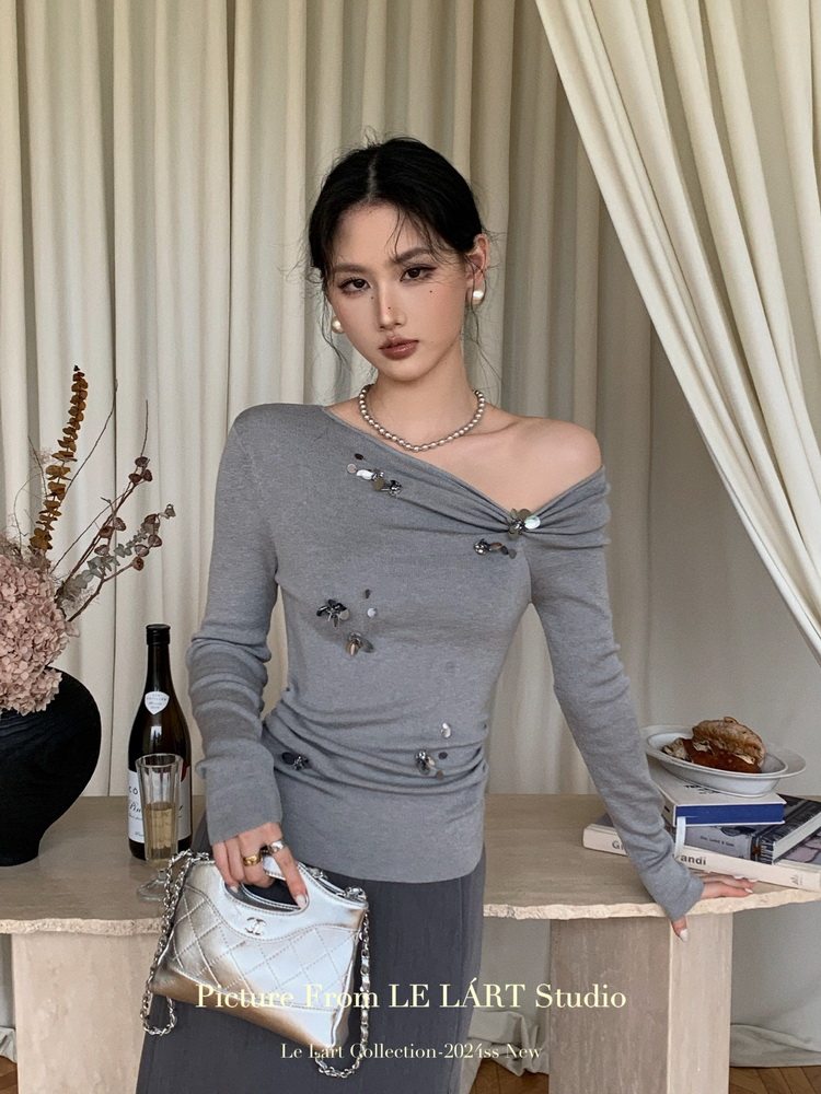 Gray off-shoulder long-sleeve embellished top worn by a model