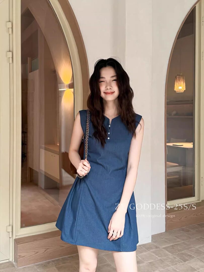 Model wearing a blue sleeveless dress indoors