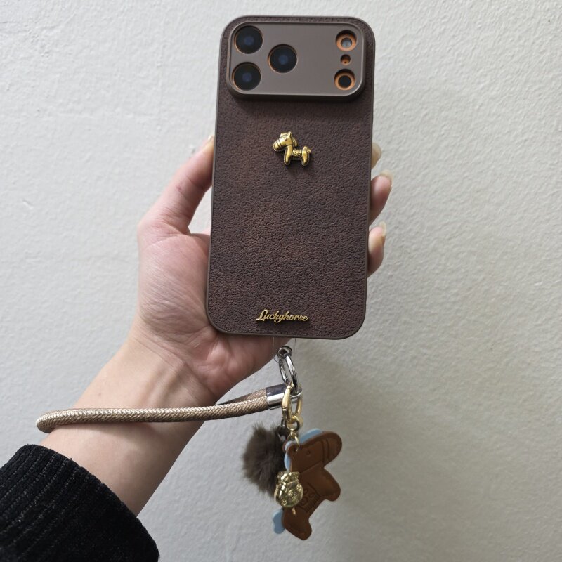 棕色月坑纹皮质立体金色小马字母iPhone17proMax手机壳苹果16pro手绳毛球15/14马挂件13promax