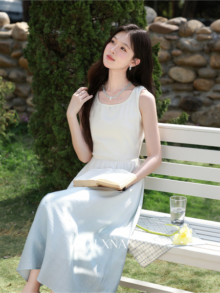 Woman wearing a light sleeveless white dress outdoors