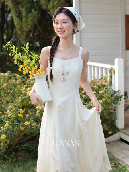 Woman wearing a white sleeveless flowy dress outdoors