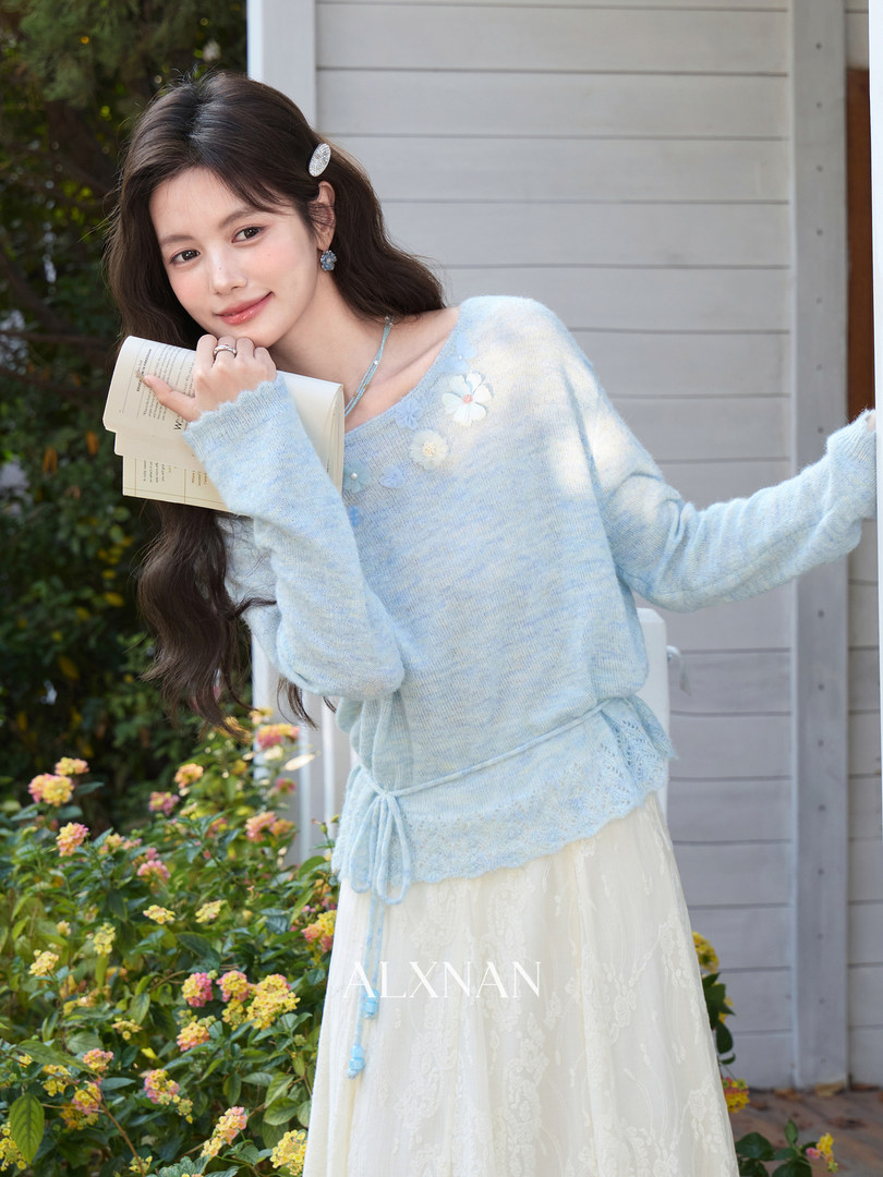 Model wearing a light blue fuzzy sweater with a cream skirt outdoors