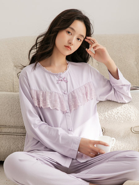 Model wearing a light lavender pajama set with lace trim and long sleeves