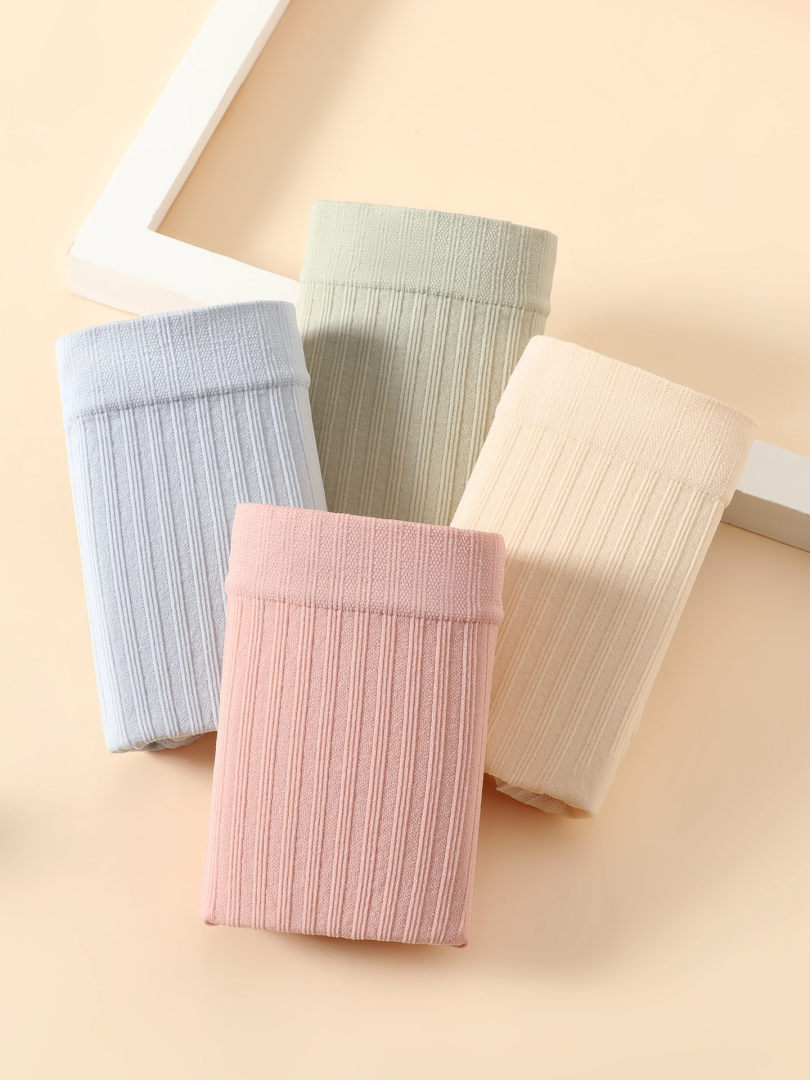Four folded ribbed knit fabric garments in pastel colors on a beige background