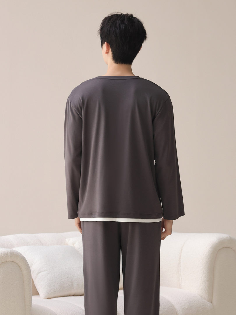 Dark gray loungewear set with long-sleeve top and matching pants worn by a model