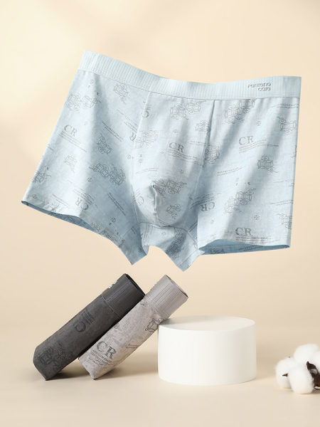 Pack of patterned men's boxer briefs in light blue, gray, and black on a studio background