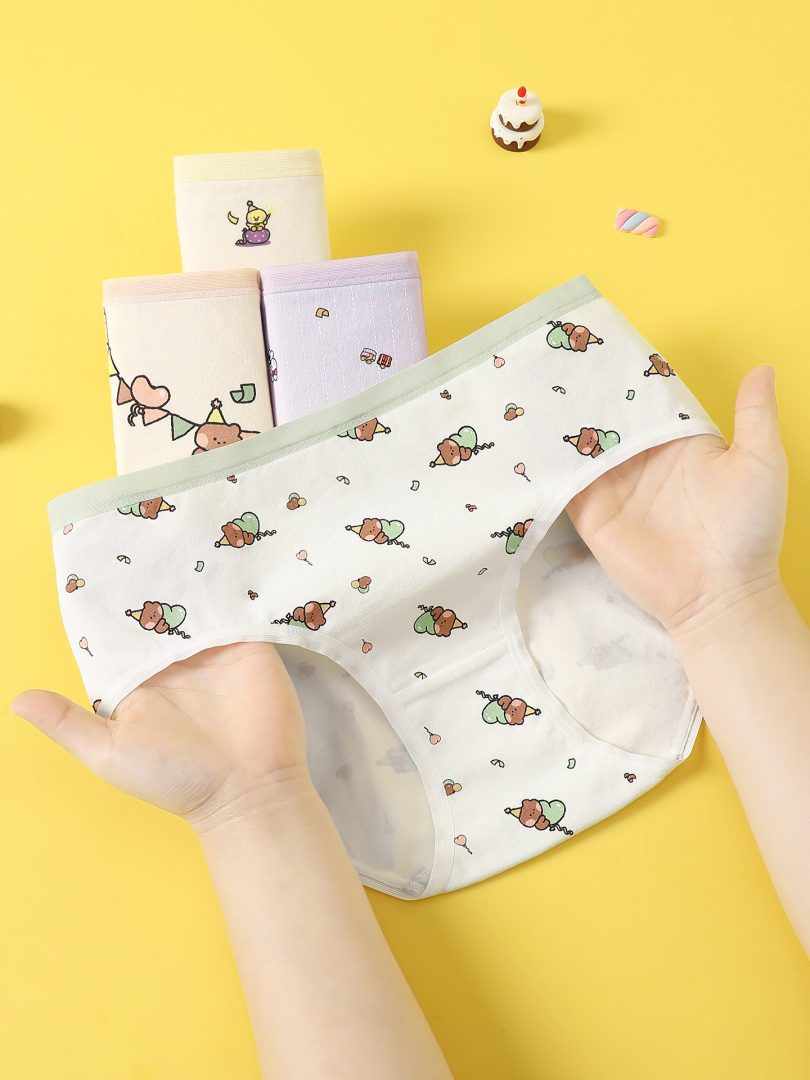 Cute patterned women's underwear held against a yellow background