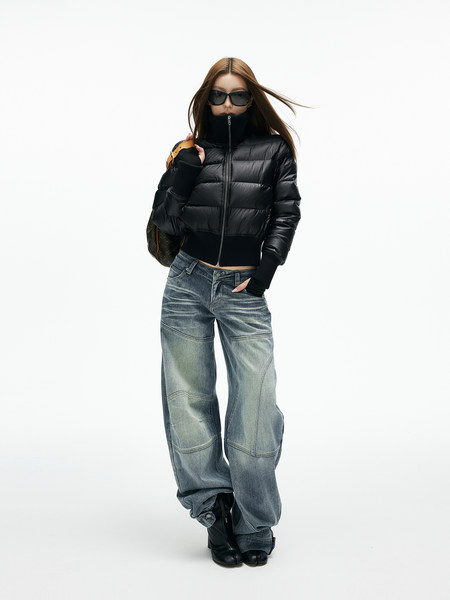 Model wearing a black puffer jacket with wide-leg blue jeans and black boots