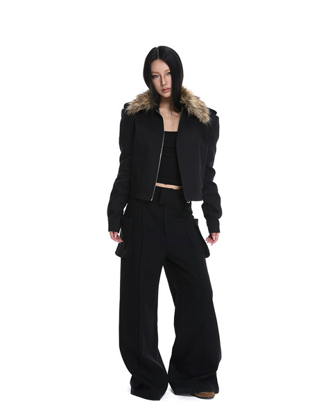 Model wearing a black cropped jacket with faux fur collar and wide-leg black pants