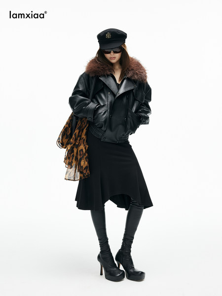Model wearing a black leather jacket with fur collar, skirt, boots, and hat