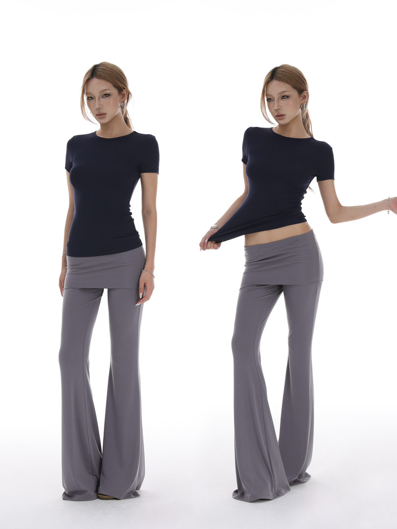 Model wearing a navy fitted short-sleeve top with gray wide-leg pants on a white background