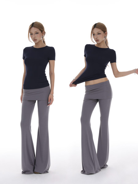 Model wearing a navy fitted short-sleeve top with gray wide-leg pants on a white background