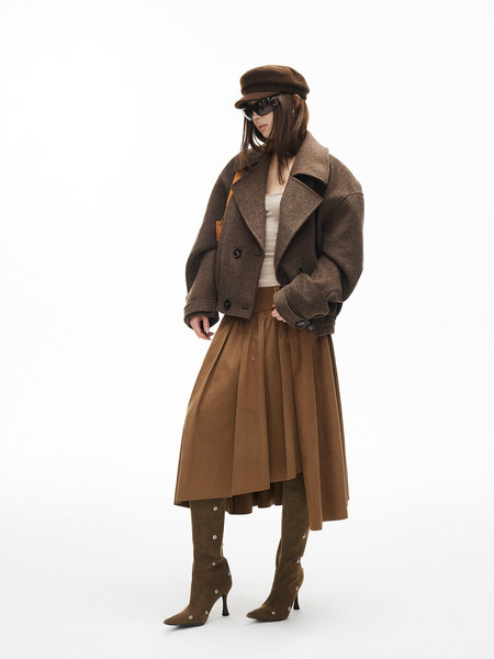 Fashion model wearing a brown oversized coat with matching skirt and heeled boots