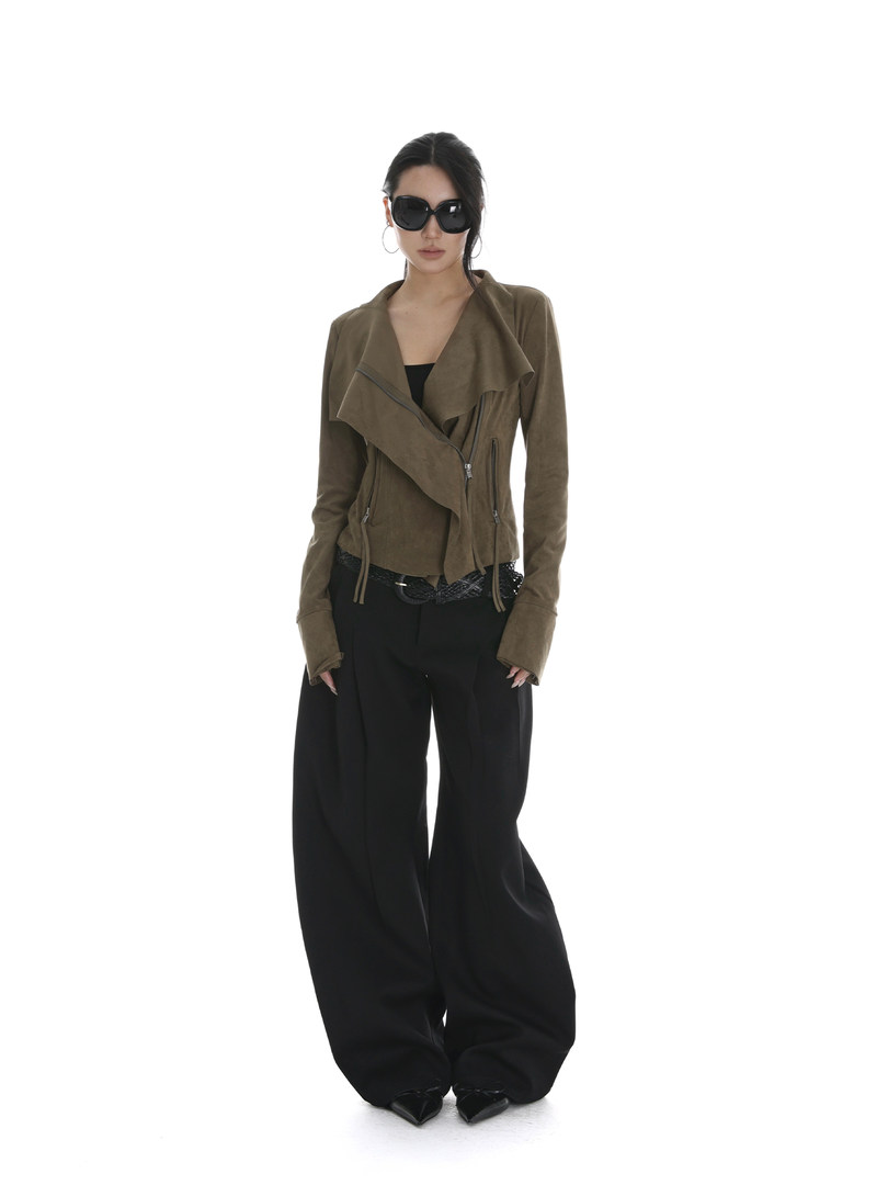 Model wearing an olive cropped jacket with wide black pants and sunglasses
