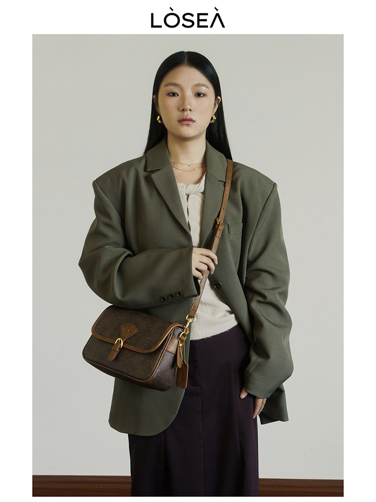 Model wearing an oversized olive blazer with a brown crossbody bag