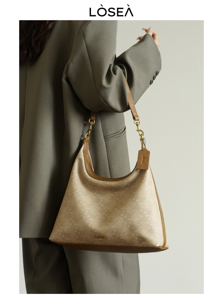 Beige patterned shoulder handbag worn by a model