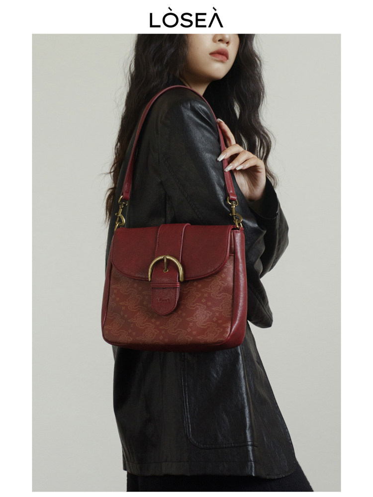 Red shoulder handbag worn by a model with a black outfit