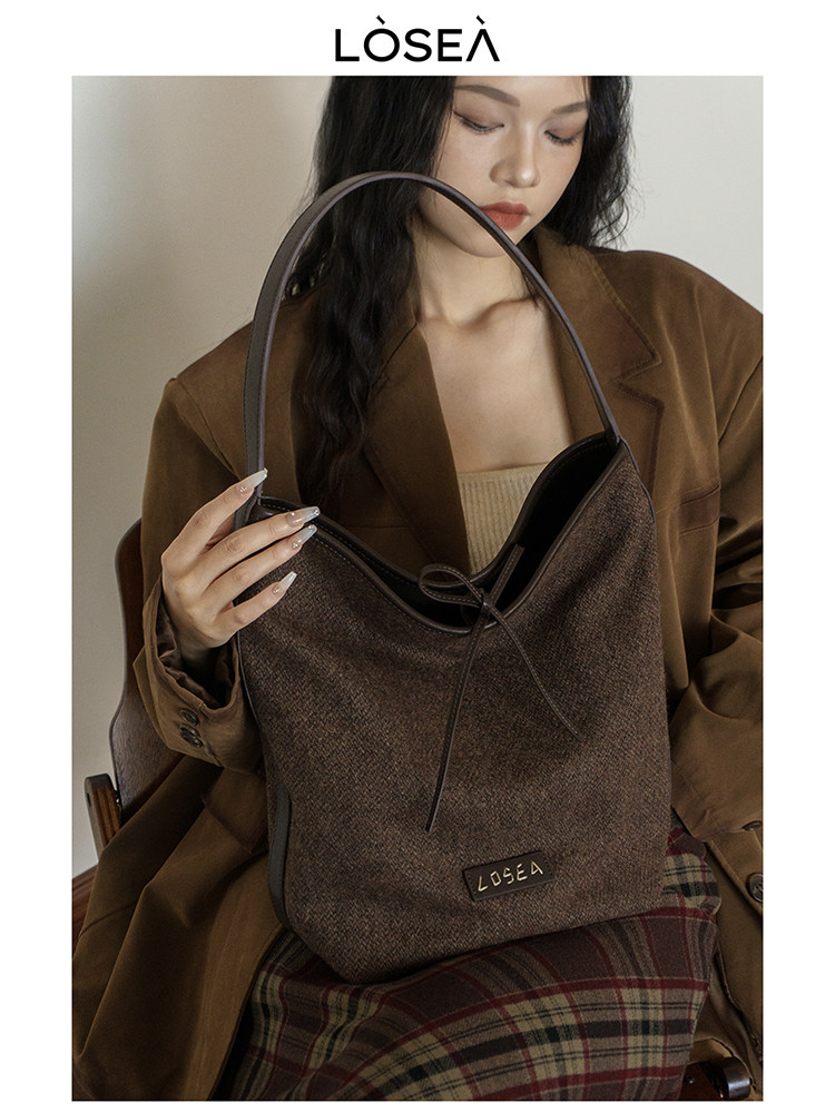 Brown textured shoulder bag held by a model