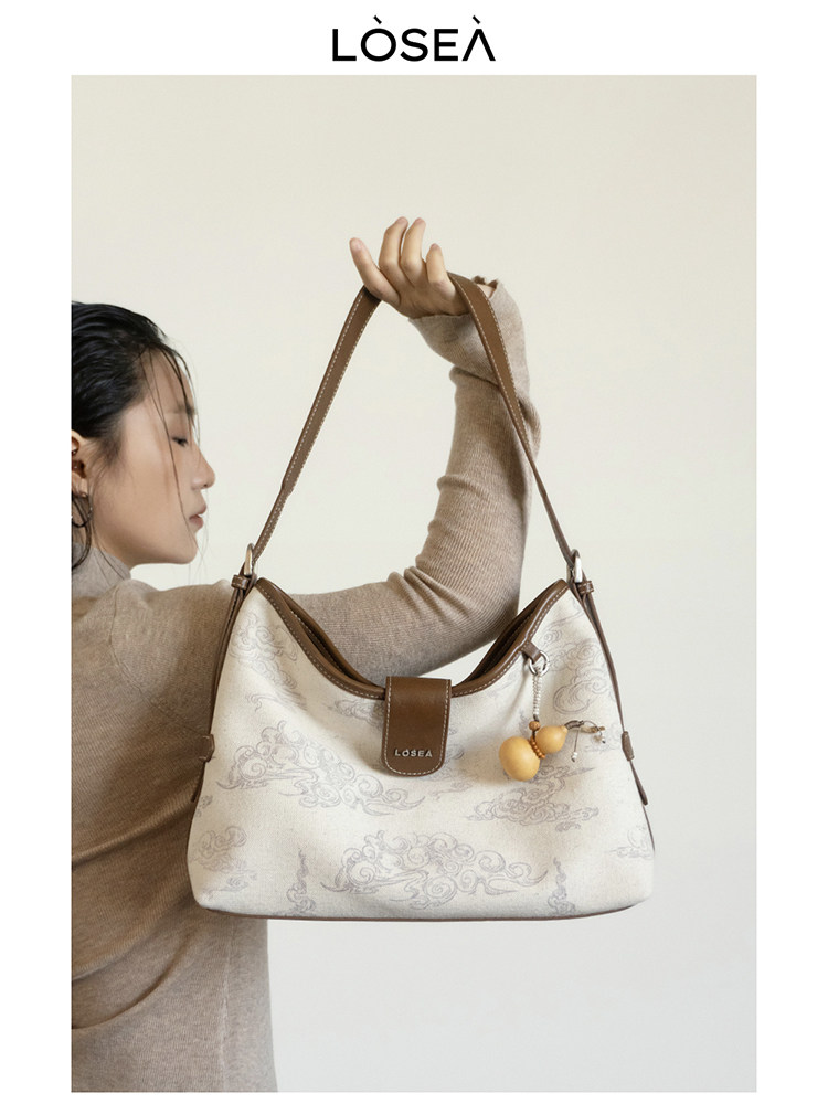 Cream and brown shoulder handbag worn by a model