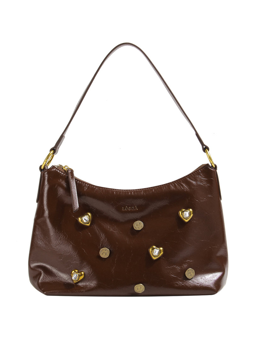 Brown leather shoulder handbag with heart-shaped stud embellishments on a white background