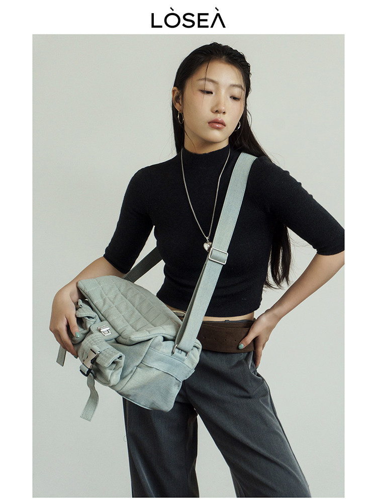 Model wearing a light blue quilted crossbody bag