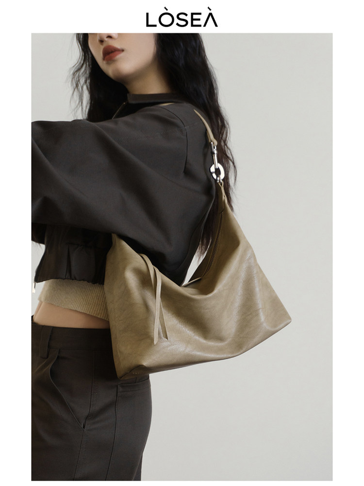 Taupe shoulder handbag worn by a model with a minimalist casual outfit