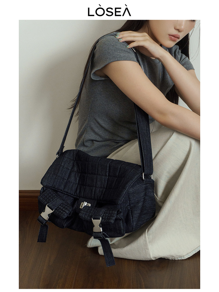 Black quilted shoulder bag worn by a model