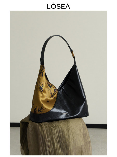 Black and gold leather shoulder handbag on display