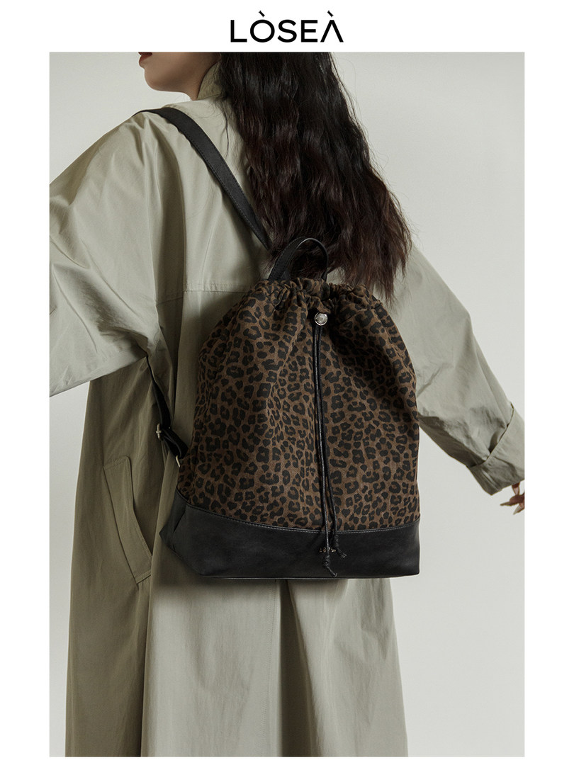 Leopard print backpack worn on a model with black trim
