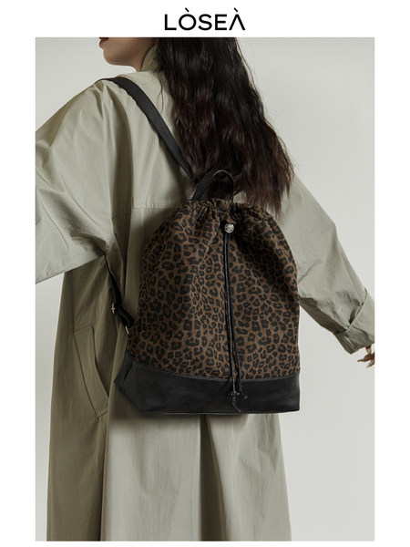 Leopard print backpack worn on a model with black trim