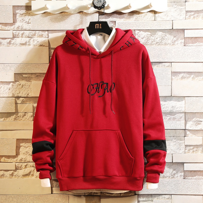 Spring hooded Pullover men's sweater splicing loose version hanging on brick wall