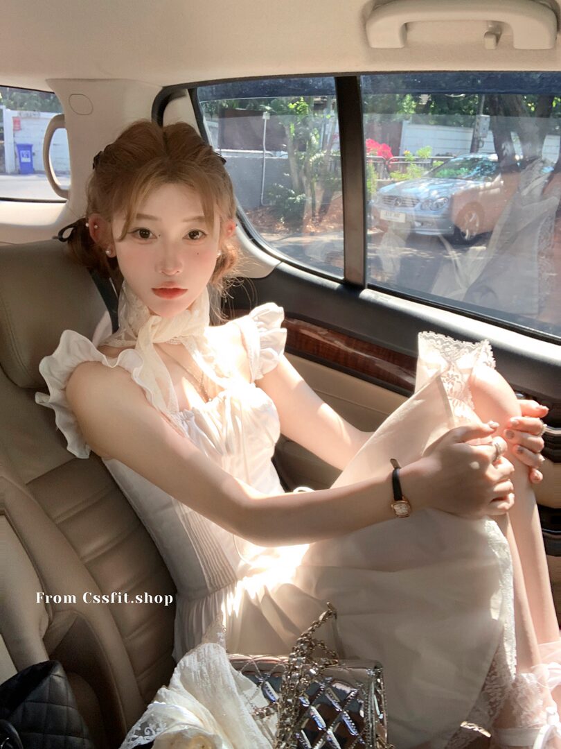 Woman wearing a white lace ruffled dress in a car