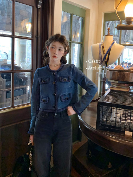 Model wearing a dark denim jacket and matching high-waisted jeans