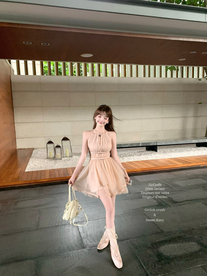 Woman modeling a blush halter dress with matching ballet flats and handbag